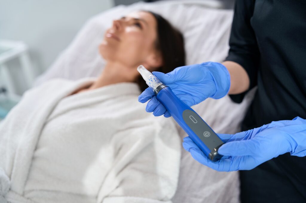 Cosmetologist holding automatic pen in microneedle mesotherapy